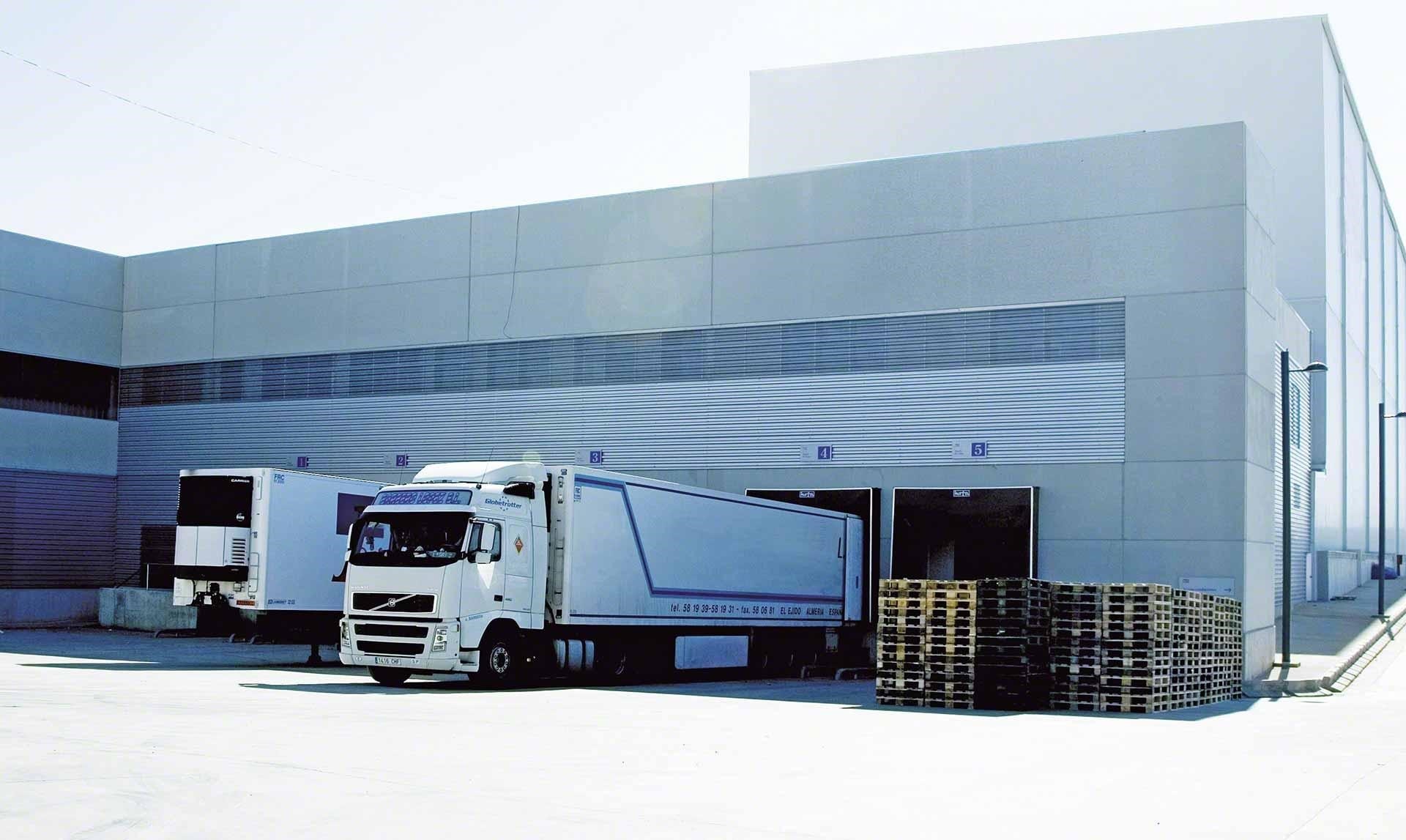 Camiones de mercaderías descargan en el depósito como parte de las operaciones de cross-docking