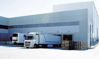 Camiones de mercaderías descargan en el depósito como parte de las operaciones de cross-docking