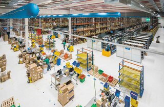 Operarios trabajan en tareas de packing o empaquetado de productos en el almacén