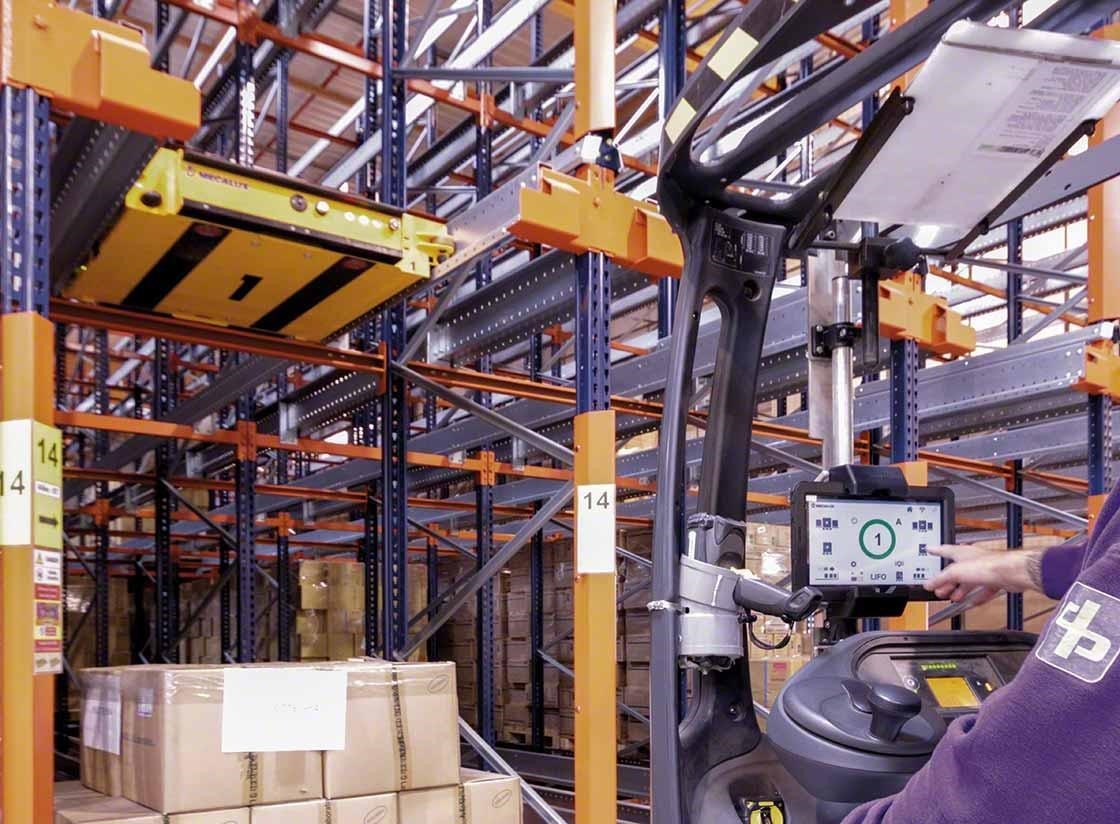 Un operario controla el carro Pallet Shuttle semiautomático desde el elevador Un operario controla el carro Pallet Shuttle semiautomático desde el elevador