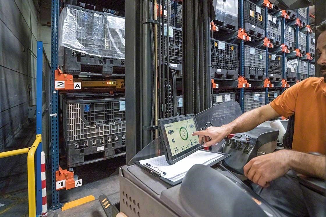 Un operario maneja el Pallet Shuttle desde un elevador con una tablet digital