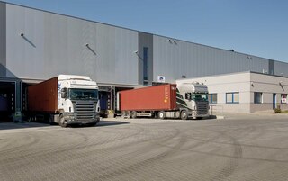 Trucks loading and unloading goods at the warehouse docks Trucks loading and unloading goods at the warehouse docks