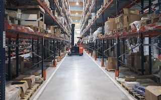 Reach truck storing returned products in a warehouse aisle
