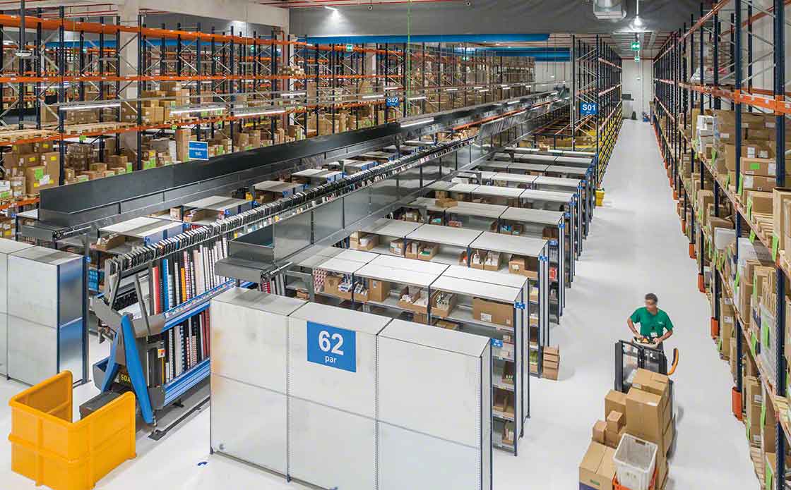 Un operario realiza tareas de picking en un depósito ayudado por una transpaleta