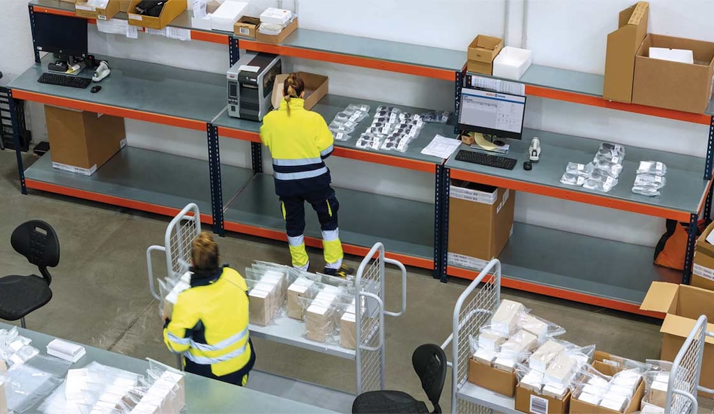 Operario controlando la preparación de pedidos en un depósito para minimizar la pérdida de tiempo de ciclo