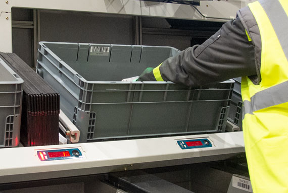 El operario coloca las referencias en las cajas correspondientes en el nivel inferior de la estación de alto rendimiento