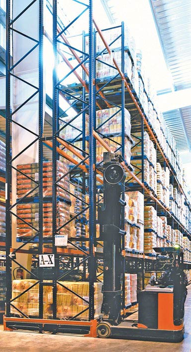 Imagen de un autoelevador retráctil de doble fondo utilizado en un depósito de productos alimentarios de gran consumo. 