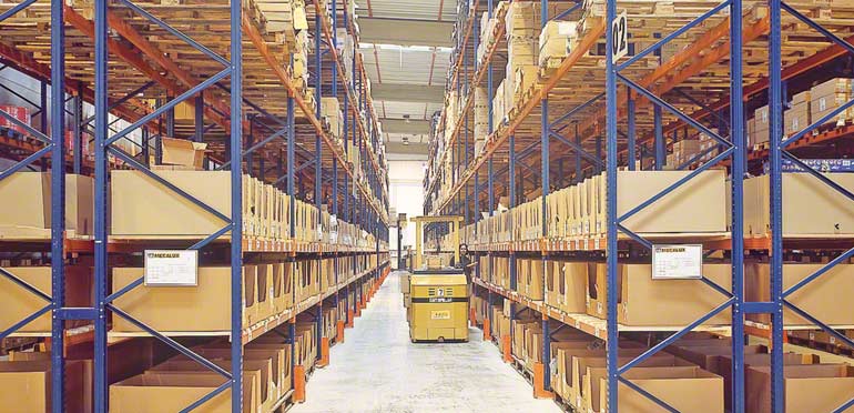 Operario trabajando en un paso inferior en una estantería convencional